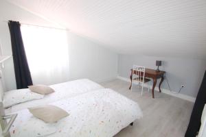 1 dormitorio con 2 camas, escritorio y ventana en Gîte les Mimosas des orgues de la Sybille, en Ille-sur-Têt