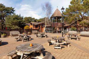 a group of picnic tables and benches in a courtyard at Beechcroft - Norfolk Cottage Agency in Holt