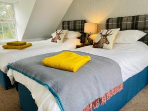 two beds with antlers on them in a bedroom at No 4 old post office row Isle of Skye - Book Now! in Eyre