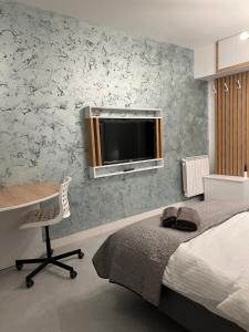 a bedroom with a bed and a desk and a television at One Room Iasi in Iaşi
