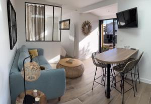 sala de estar con sofá azul y mesa en Lodge LE CABANON accès direct plage !, en La Turballe