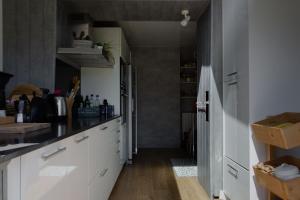 a kitchen with white cabinets and a wooden floor at SAVANNAH in Saint Malo