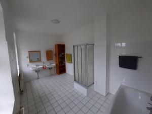 ein Badezimmer mit zwei Waschbecken und einer Badewanne und zwei Waschbecken in der Unterkunft Gwuni's Farm in Geithain