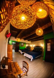 a bedroom with two beds and chandeliers in a room at Posada de la Virgen in Tlaxcala de Xicohténcatl