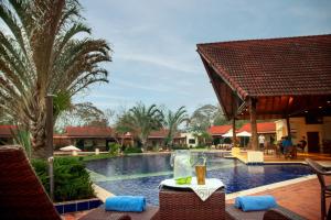a table with a drink on it next to a swimming pool at Alta Gracia Parque Hotel in Caacupé