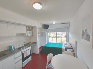 a small kitchen with a table and a bed in a room at Depto Mancora in Rosario