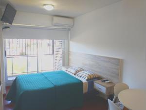 a bedroom with a bed and a large window at Depto Mancora in Rosario