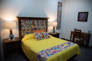 1 dormitorio con 1 cama, 2 lámparas y 1 silla en Posada de la Virgen, en Tlaxcala de Xicohténcatl