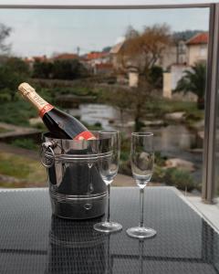 Una botella de vino y dos copas en una mesa. en Hotel A Ponte, en Viana do Castelo