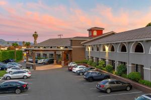 a group of cars parked in a parking lot in front of a hotel at Best Western Plus Brookside Inn in Milpitas