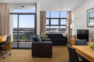 a living room with a couch and a table at Rydges Mackay Suites in Mackay