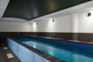 a large swimming pool with blue water in a room at Rydges Mackay Suites in Mackay