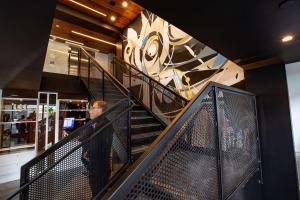 Ein Mann, der eine Treppe hinuntergeht, mit Wandmalereien in der Unterkunft Yotel San Francisco in San Francisco