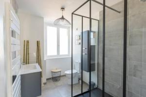 a bathroom with a shower and a toilet and a sink at Villa des Arts in Épernay