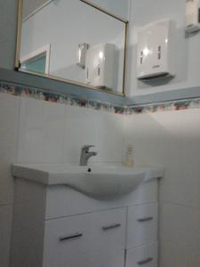 a white sink sitting under a mirror in a bathroom at Gecko's Rest Budget Accommodation & Backpackers in Mackay