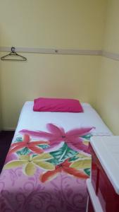 a bed that has a pink blanket on it at Gecko's Rest Budget Accommodation & Backpackers in Mackay