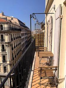 a balcony with two tables and benches on a building at LaFrenchCasa Canebière in Marseille