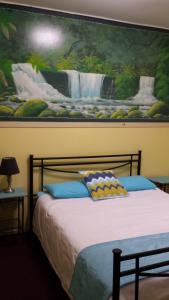 a bedroom with a bed and a painting on the wall at Gecko's Rest Budget Accommodation & Backpackers in Mackay