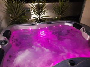 eine lila Badewanne mit rosafarbener Beleuchtung im Bad in der Unterkunft SOL34 in Torrevieja