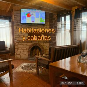 sala de estar con chimenea y TV en la pared en Hotel y Cabañas Alan en Chignahuapan