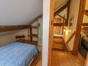 um quarto e um quarto com uma cama e uma escada em Beudy Dolpebyll em Llangadfan