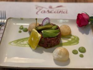Hotel Toscana في بورنا: طبق ابيض عليه قطعة اكل
