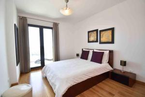 Un dormitorio con una cama y una ventana grande. en Rubeus, en Caniço 27 fotos más