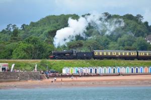a train traveling past a beach with a train at High gables Apartment 1 in Paignton