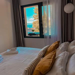 1 dormitorio con cama con almohadas y ventana en Pine Resort, en Polychrono