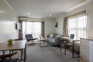 a living room with a couch and a table at Quest Auckland Serviced Apartments in Auckland