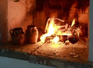 ナルドにあるMasseria Nucci - Autentica Dimora Storicaの暖炉の前でワイン1杯