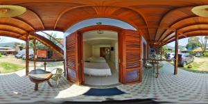 Duży pokój z łóżkiem i lustrem w obiekcie Pousada Villa Maritima w mieście Trindade