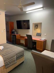 a hotel room with a bed and a desk at Cannon Park Motel in Cairns