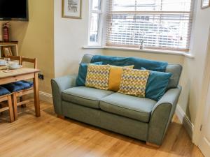 een blauwe bank met kussens in de woonkamer bij Apartment 6 in Whitby