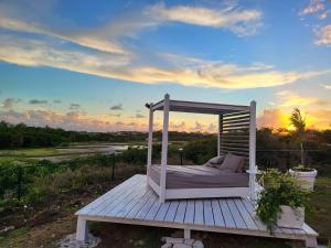 a bed on a wooden platform with the sunset in the background at Unique Rare Villa! Retreat Style, Full Sea Views With Private Pool & Hot Tub! villa in Christ Church