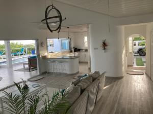 ein Wohnzimmer mit einem Sofa und einer Küche in der Unterkunft Unique Rare Villa! Retreat Style, Full Sea Views With Private Pool & Hot Tub! villa in Christchurch