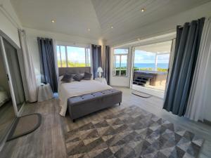 Schlafzimmer mit einem Bett und Meerblick in der Unterkunft Unique Rare Villa! Retreat Style, Full Sea Views With Private Pool & Hot Tub! villa in Christchurch