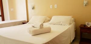 um quarto com 2 camas e toalhas em Pousada Villa Maritima em Trindade