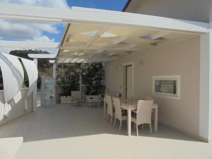 a patio with a table and chairs on a deck at La Poesia in Rocca Imperiale