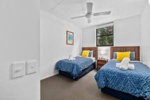 um quarto com 2 camas e uma ventoinha de tecto em Your place. Enjoy the beach retreat em Rainbow Beach