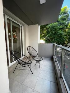 a balcony with two chairs and a table and chairs at FIRENZE in Rosario