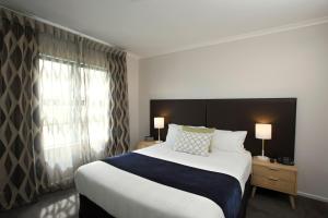 a hotel room with a large bed and a window at Quest Auckland Serviced Apartments in Auckland
