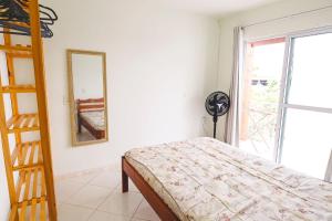 1 dormitorio con cama, escalera y espejo en Morada do Mar Aberto - 100 metros da praia, en Palhoça