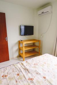 1 dormitorio con 1 cama y TV de pantalla plana en Morada do Mar Aberto - 100 metros da praia, en Palhoça