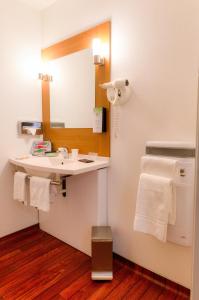 a bathroom with a sink and a mirror at Kyriad Quimper - Pont-l'Abbé in Pont-lʼAbbé