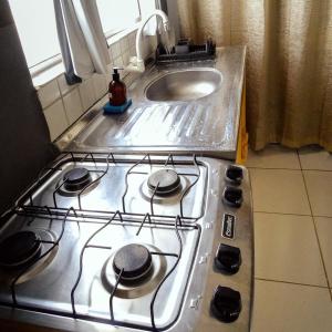 a stove top oven in a kitchen next to a sink at Flats Fortal Preá in Prea