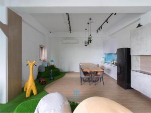 a living room with a table and a kitchen at Muco Muco Bnb in Yilan City