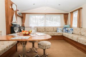 a living room with a table and a couch at Solent Breezes, Caravan 108 in Southampton