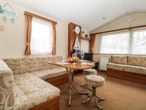 a living room with a couch and a table at Solent Breezes, Caravan 108 in Southampton