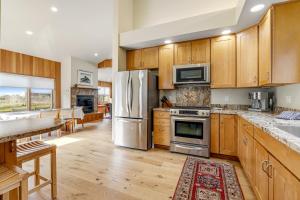 uma cozinha com armários de madeira e electrodomésticos de aço inoxidável em Leeward Ocean Retreat em Sea Ranch